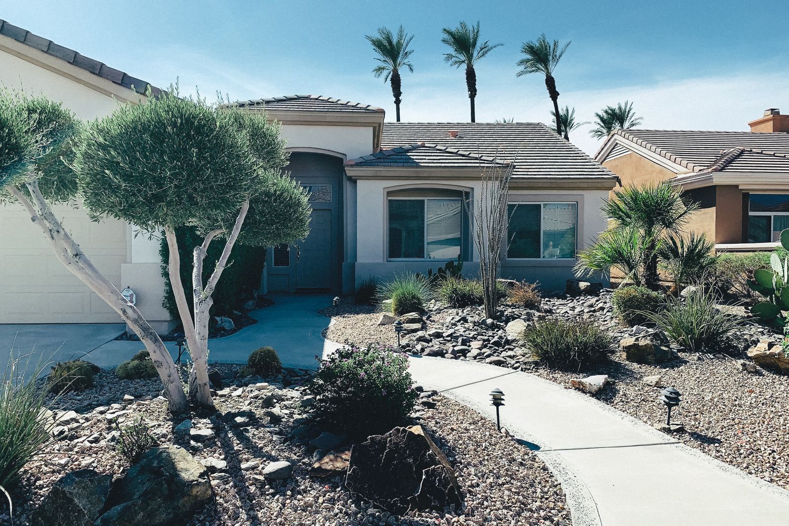 Single-story stucco ranch home with tile roof and desert cactus landscaping representing the West Side
